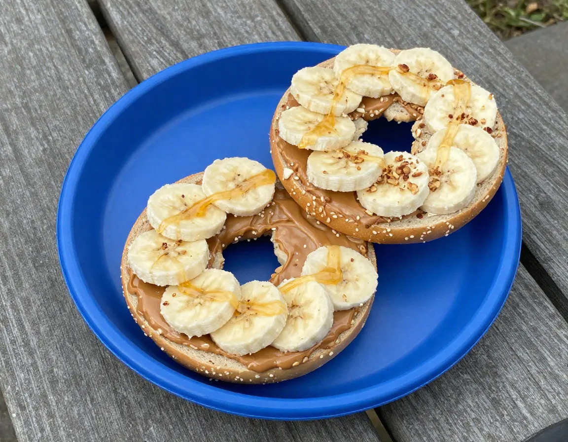 Peanut butter bagel with banana slices and honey on plate