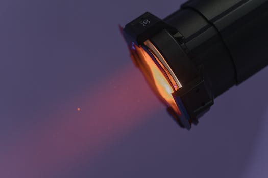 A close-up shot of a flashlight projecting warm light in a dark setting.