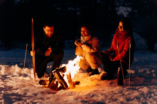 Three friends enjoying a campfire in a snowy winter setting. Warmth in winter.