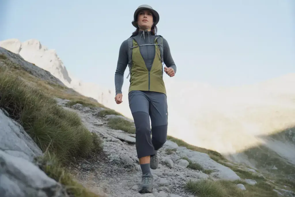 Alpine Day Hiker In Merino Wool And Soft Shell Jacket On Mountain Trail