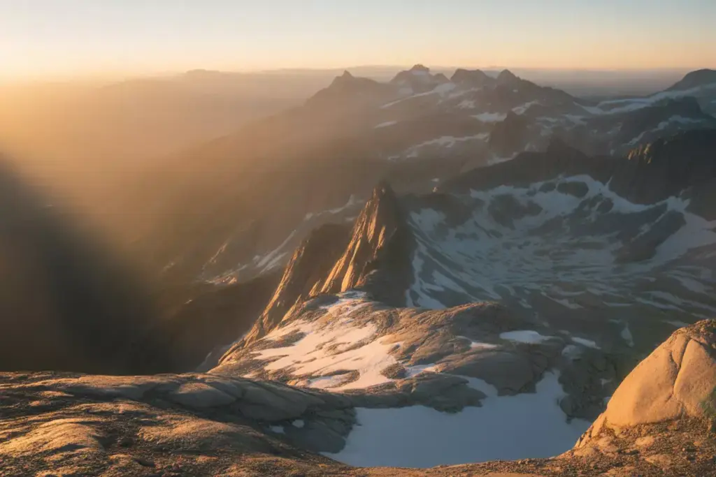 Master The Art Of Mountain Lighting And Timing At Golden Hour With Warm Sunlight And Dramatic Shadows On Textured Rock And Snow Fields