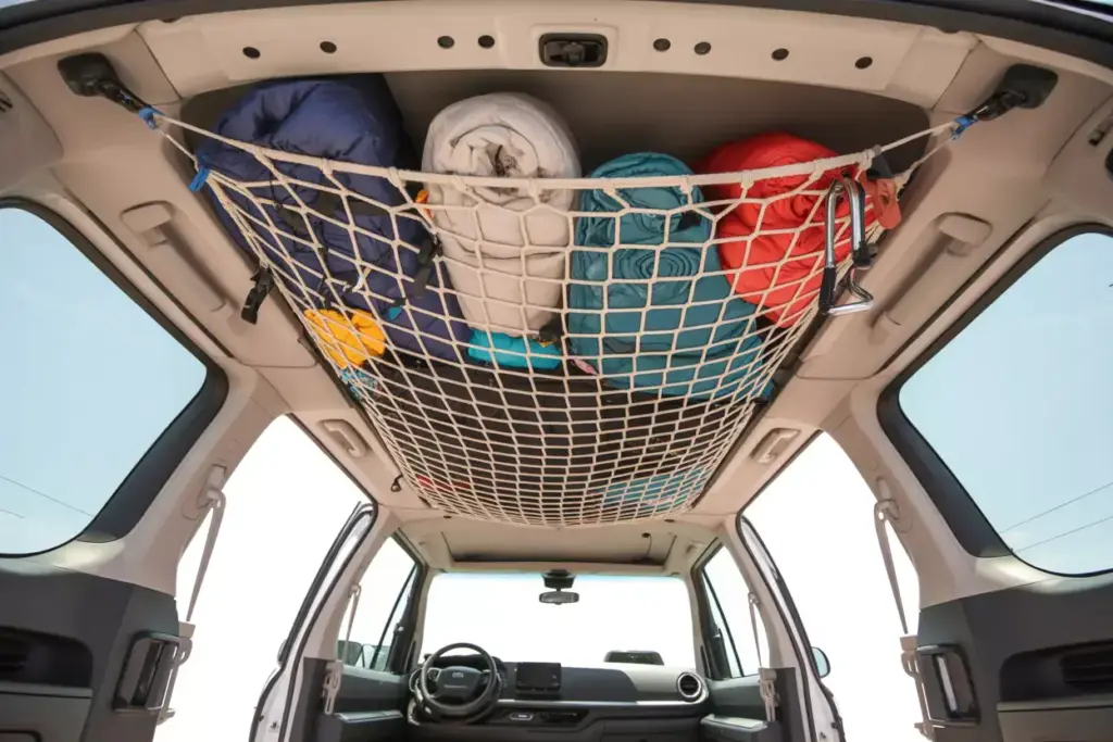 Overhead Cargo Net Storage System Loaded With Camping Gear In Minivan Ceiling