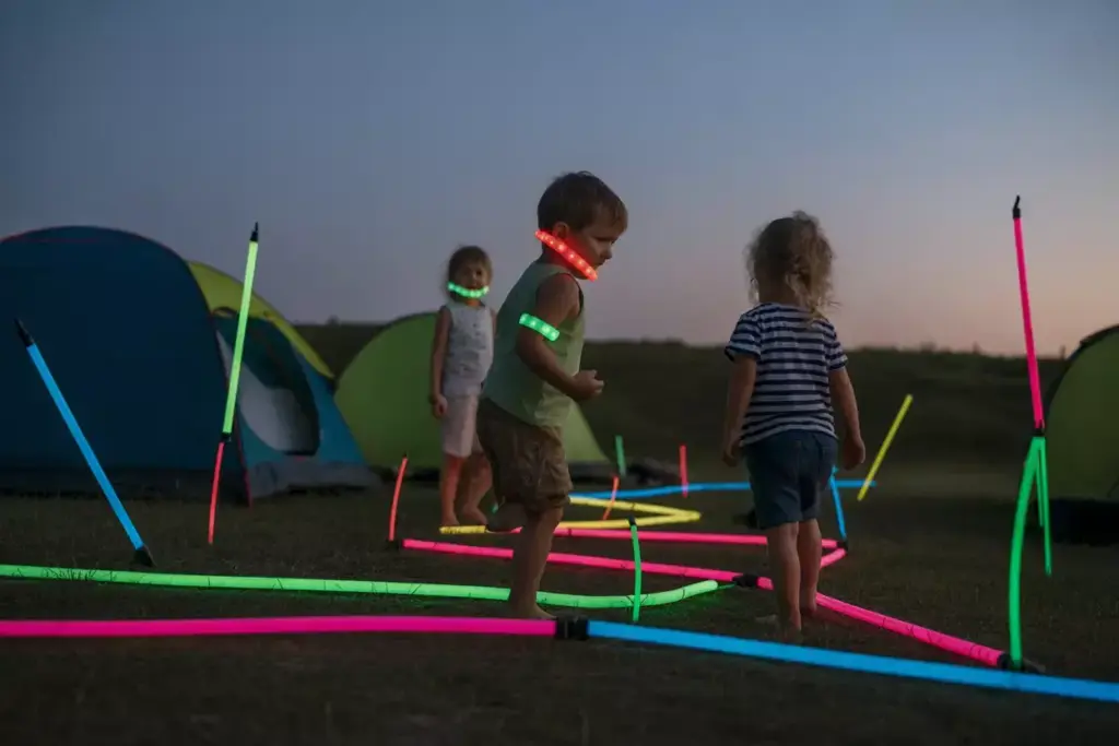 Campsite At Dusk With Glow Sticks Marking Tents Pathways And Kids Wearing Them