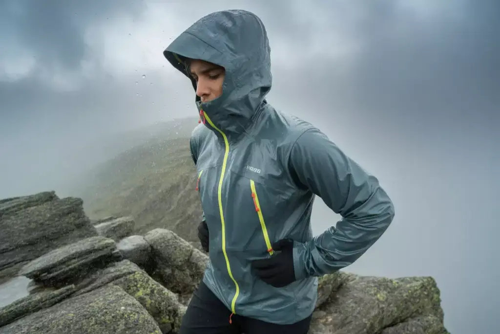 23 Hiker In Waterproof Shell Jacket Facing Wind Rain On Mountain Ridge