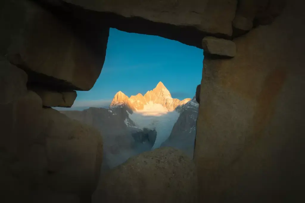 36 Distant Mountain Peak Framed By A Dark Natural Rock Arch Formation
