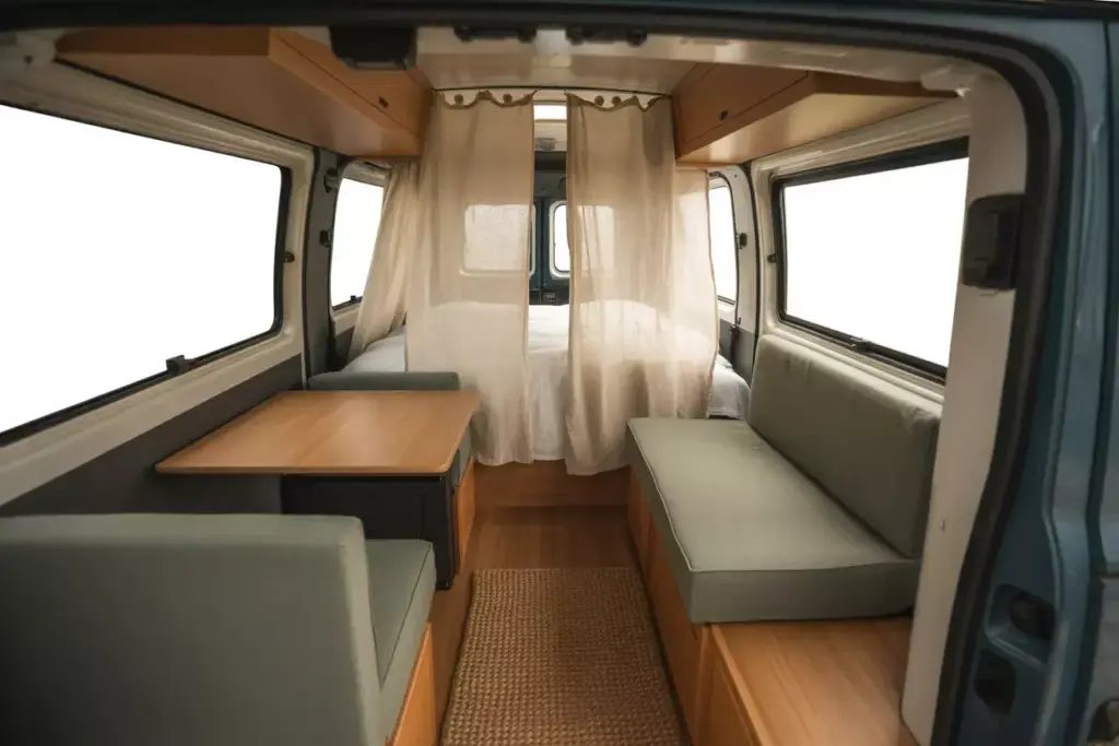Camper Van Interior Showing Defined Sleeping And Dining Zones With A Curtain