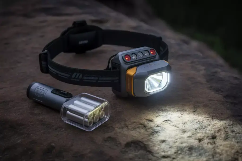 Headlamp Casting A Beam With Backup Flashlight And Batteries